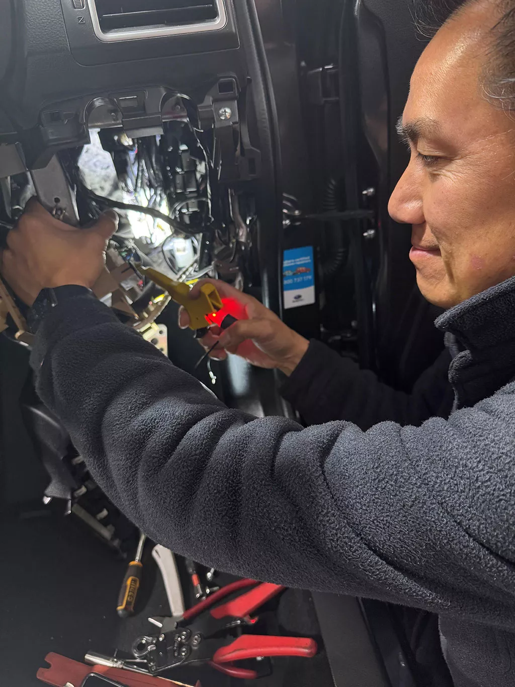 Technician smiling while servicing a car