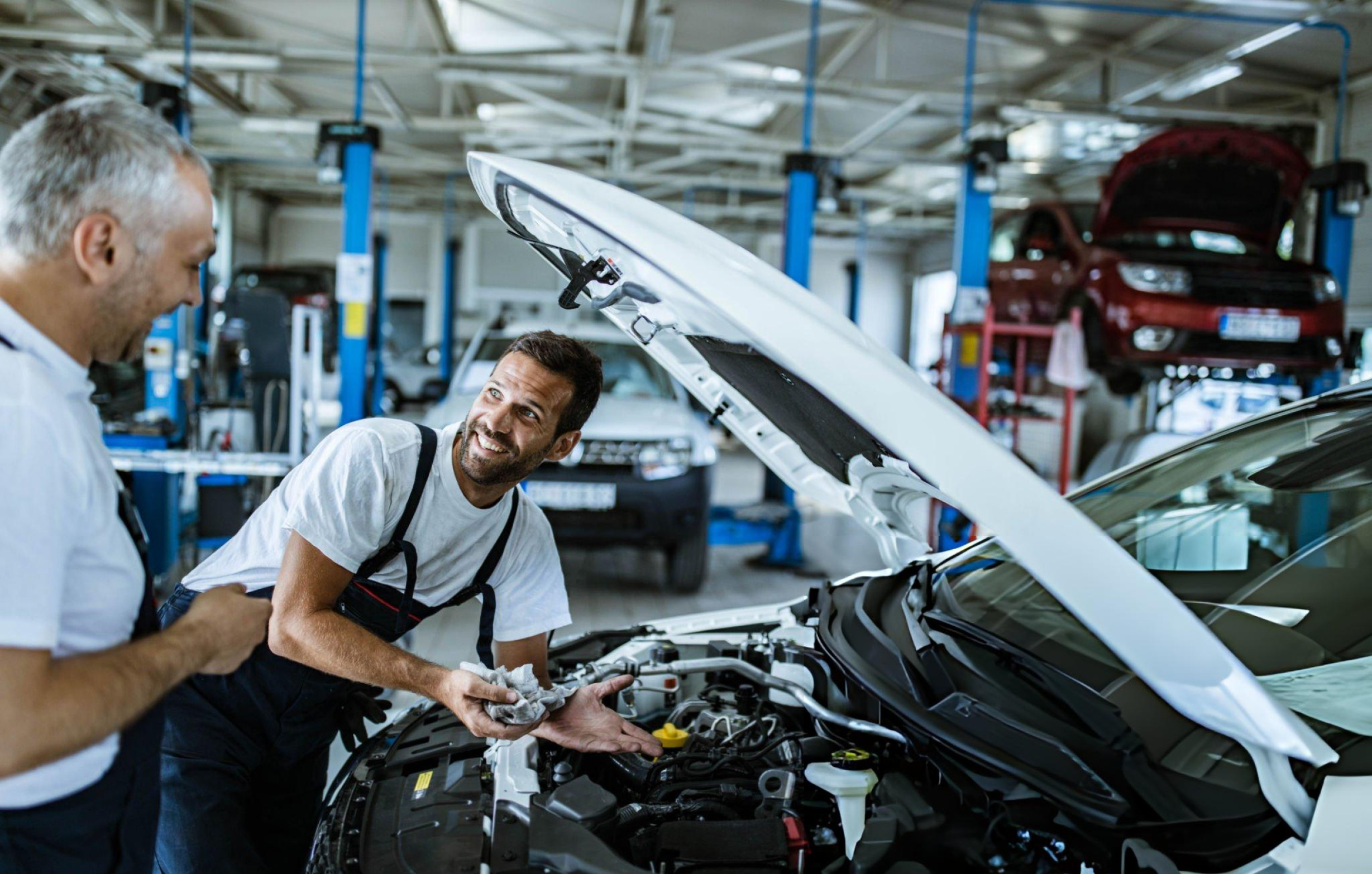 Technician smiling while servicing a car